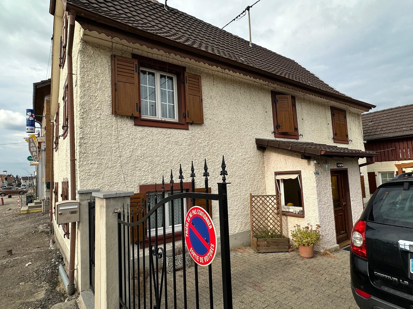 La même maison avant travaux, crépi blanc très texturé et encrassé