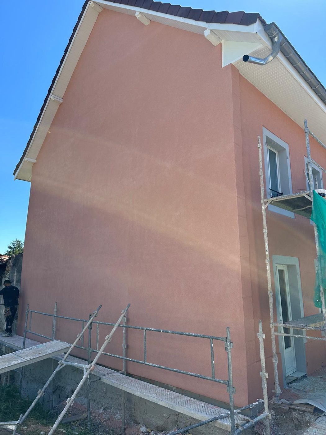 Le même pignon en cours de travaux, enduit terracotta fraîchement appliqué sous échafaudage