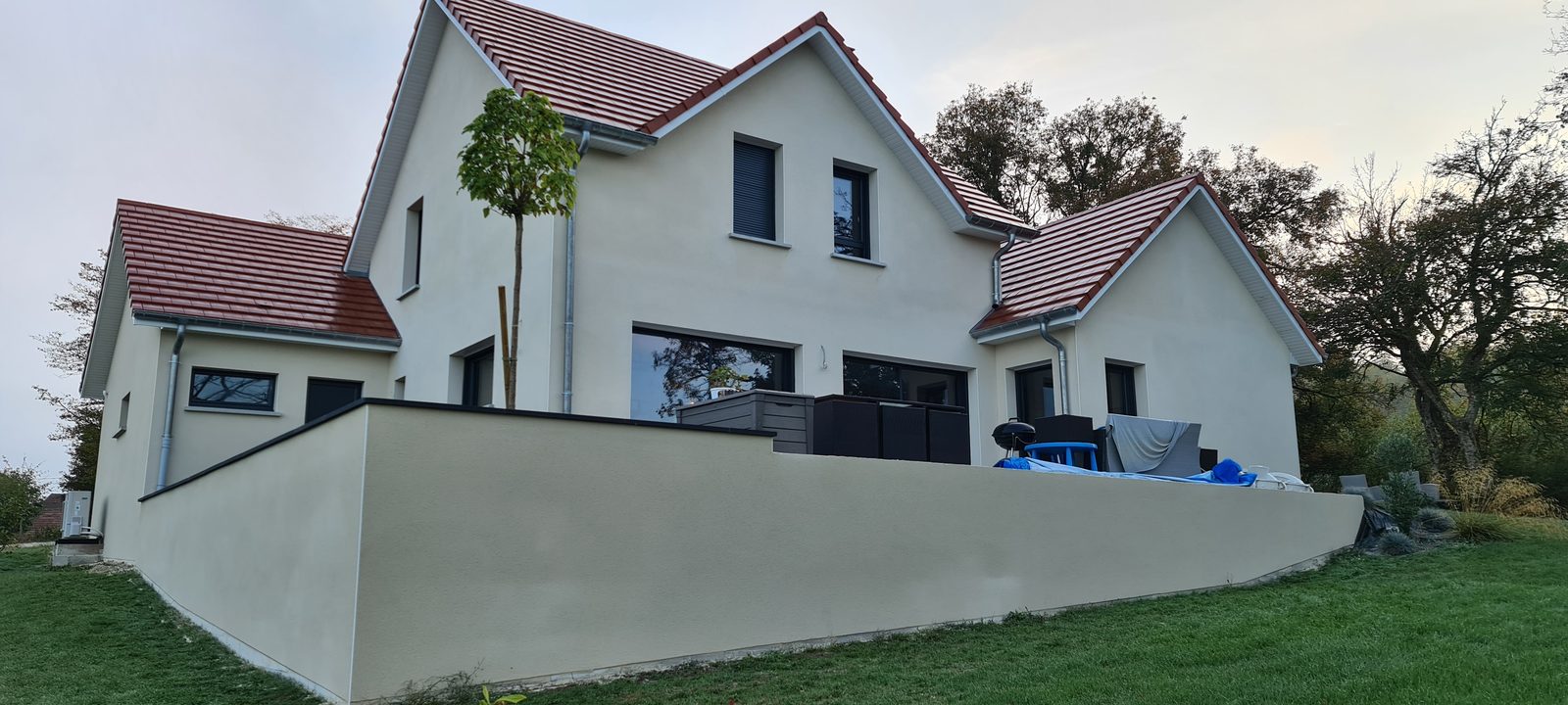 Vue arrière de la même maison, façade et mur de terrasse enduits